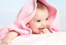 Infant wrapped in pink towel.